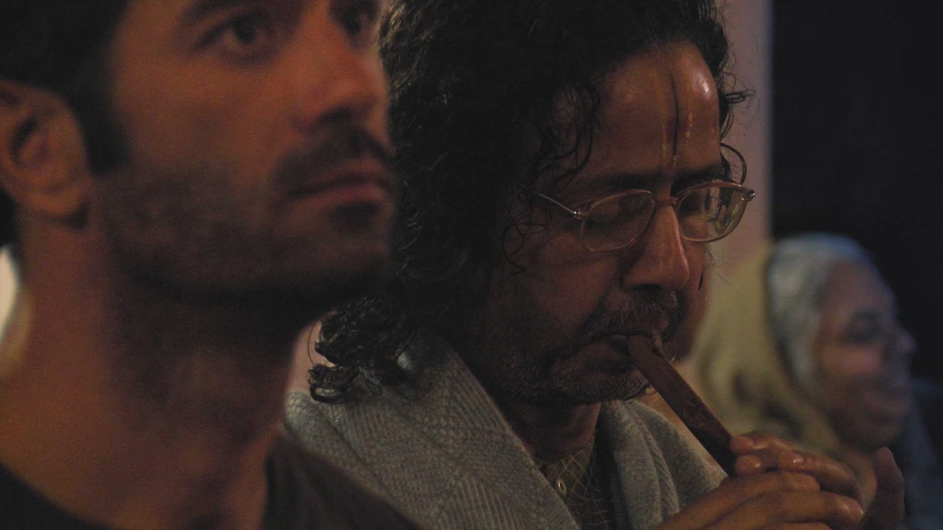Dinesh Goswami Plays Flute at Radha Raman temple, a still from a multi-award winning 'Reconnection' film.