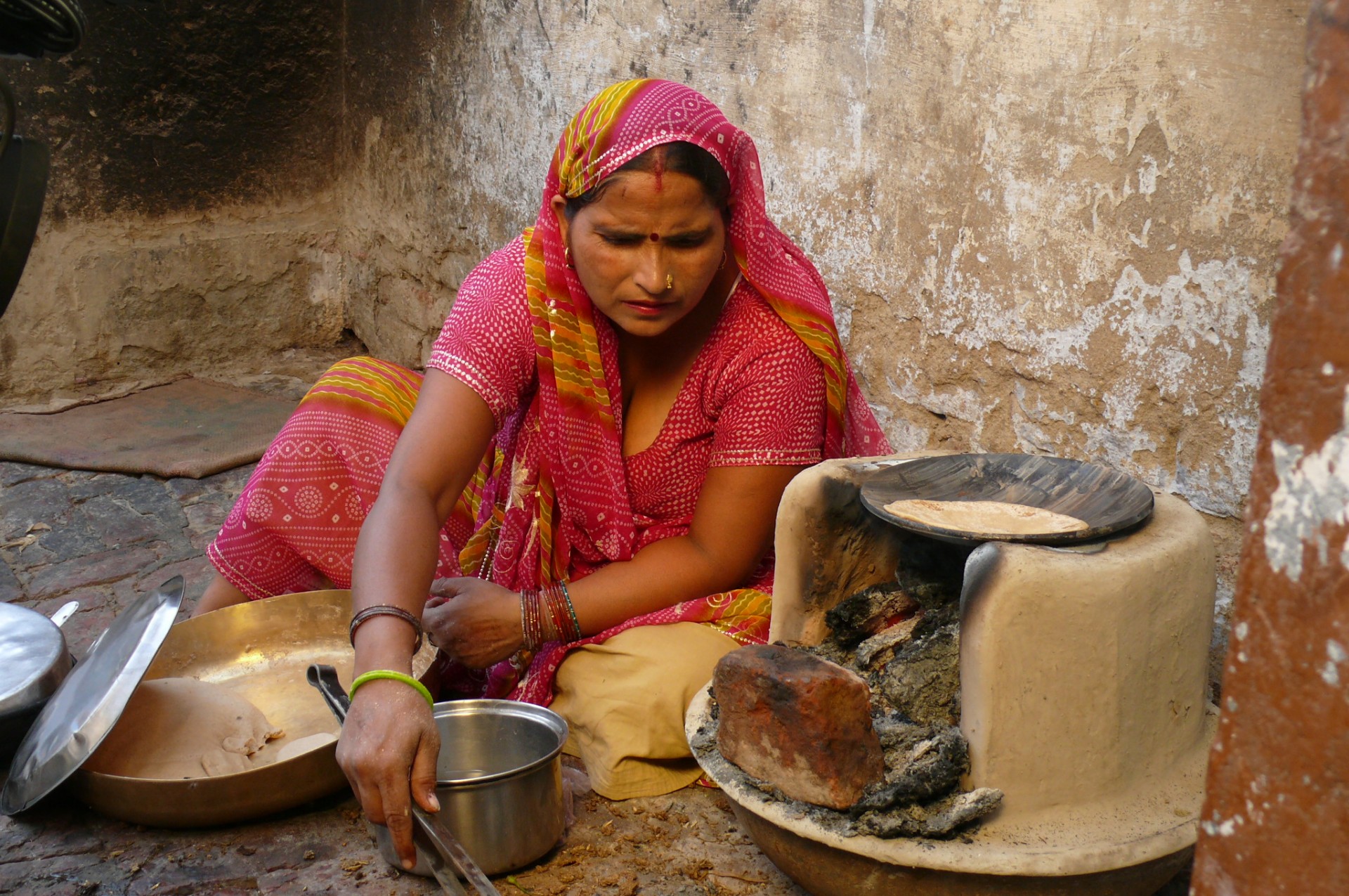 Cooking on a stove that works on a cow dung. During the village lunch scene of the 'Reconnection', an award-winning film.